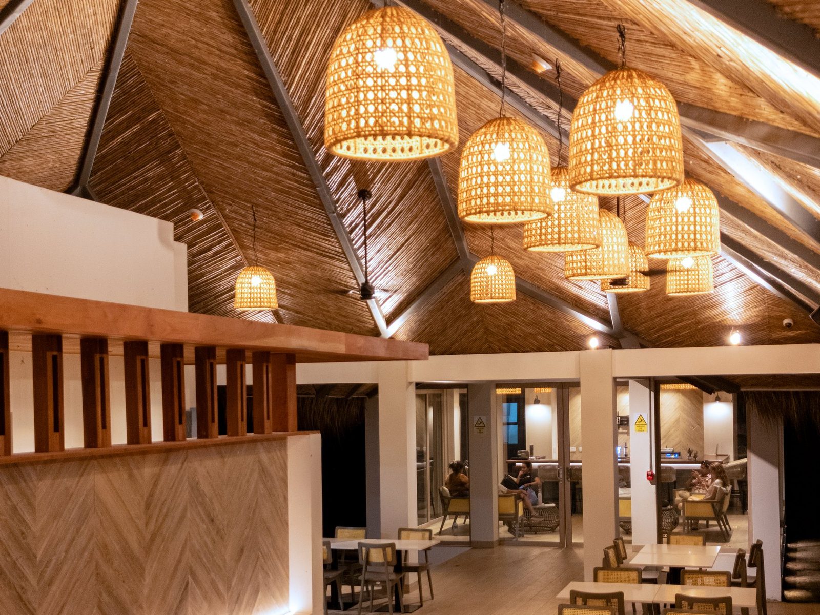 Restaurante Nakawé: comedor con techo de caña y lámparas de ratán
